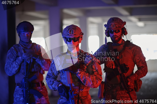 Image of soldier squad team portrait in urban environment colored lightis