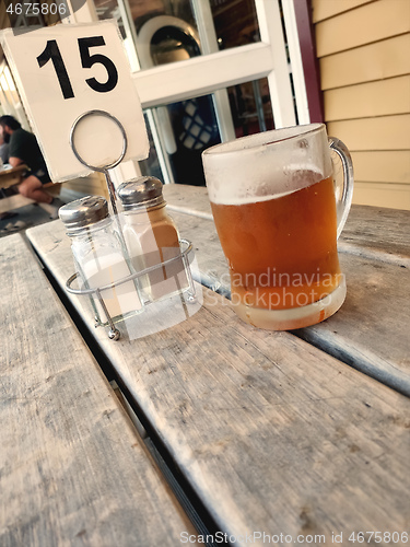 Image of glass of beer outside on a wooden table