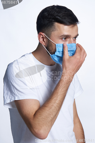 Image of Young man wearing adjusting his medicine mask