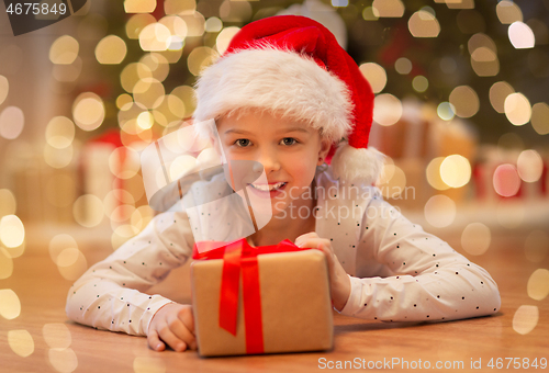 Image of smiling girl in santa hat with christmas gift