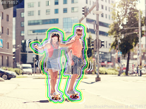 Image of teenage couple riding skateboards on city street