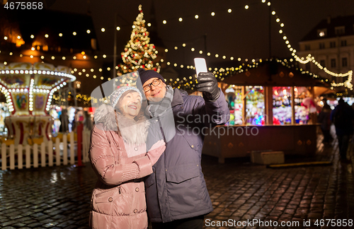 Image of senior couple taking selfie at christmas market