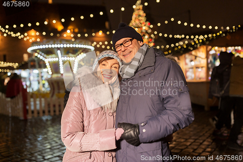 Image of happy senior couple hugging at christmas market