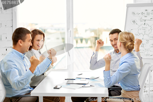 Image of happy business team celebrating seccess at office