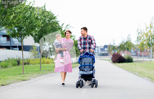 Image of family with baby and stroller walking along city