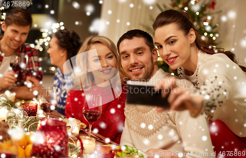 Image of friends having christmas dinner and taking selfie