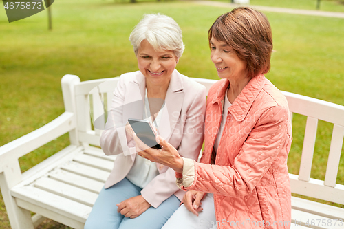 Image of happy senior women with smartphone at summer park