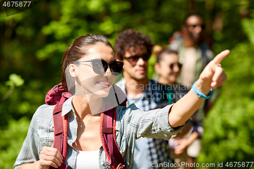 Image of group of friends with backpacks hiking in forest