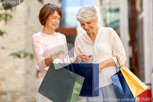 Image of senior women with shopping bags in city