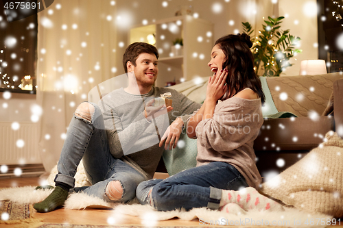 Image of happy couple with gift box at home