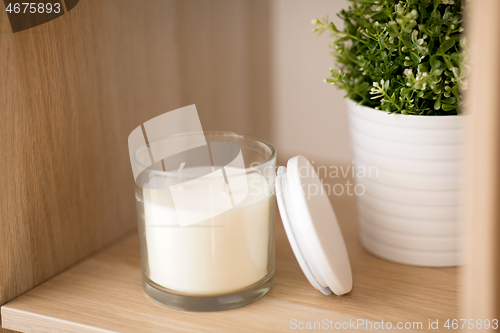 Image of fragrance candle in glass holder on shelving