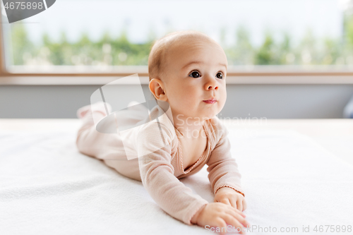 Image of sweet baby girl lying on white blanket