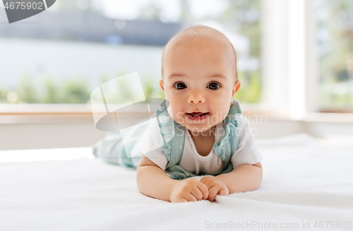 Image of sweet baby girl lying on white blanket