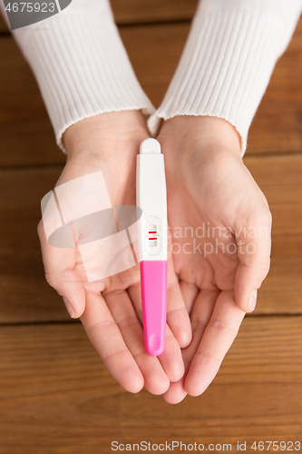 Image of woman hands holding positive pregnancy test