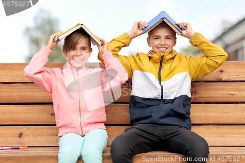 Image of school children with books having fun outdoors