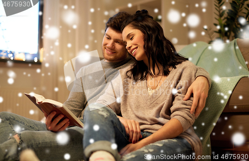 Image of happy couple reading book at home