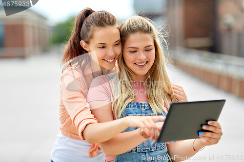 Image of teenage girls with tablet computer on roof top