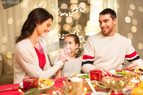 Image of happy family having christmas dinner at home