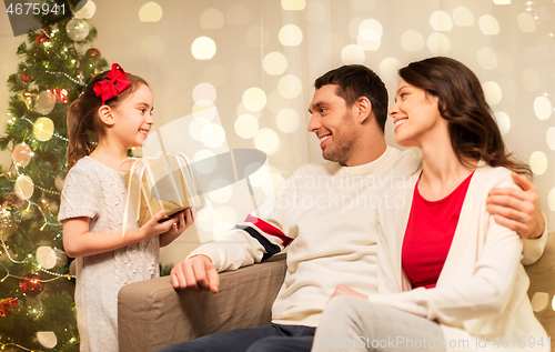 Image of happy family with christmas present at home