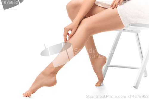 Image of Beautiful female legs isolated on white background. Beauty, cosmetics, spa, depilation, treatment and fitness concept, sensual posing