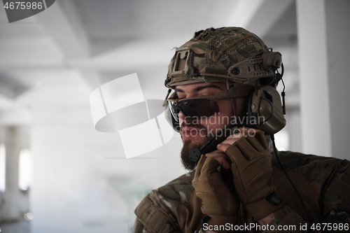 Image of soldier preparing tactical and commpunication gear for action battle