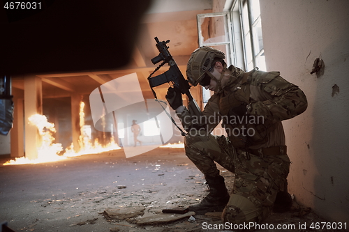 Image of soldier in action near window changing magazine and take cover