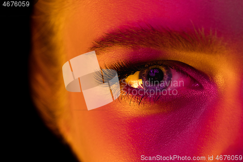 Image of Close up portrait of female fashion model in neon light on dark studio background.