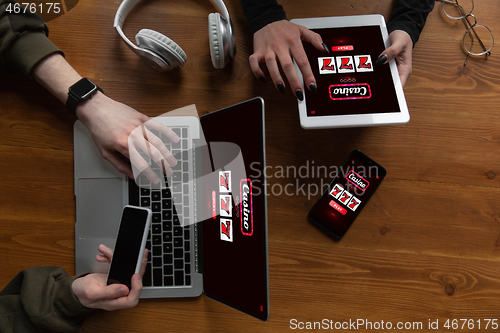 Image of Close up laptop and smartphone screen with mobile app for online casino lottery