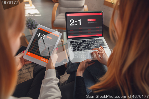 Image of Close up laptop and smartphone screen with mobile app for betting and score