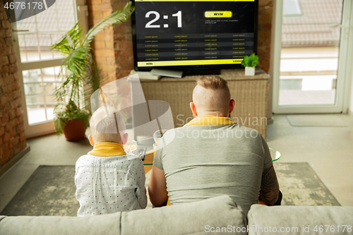 Image of TV screen with mobile app for betting and score, cheering friends, fans in front of it look excited