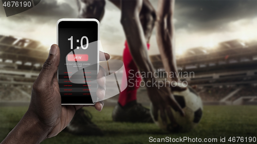 Image of Smartphone screen with mobile app for betting and score, sportsman on background