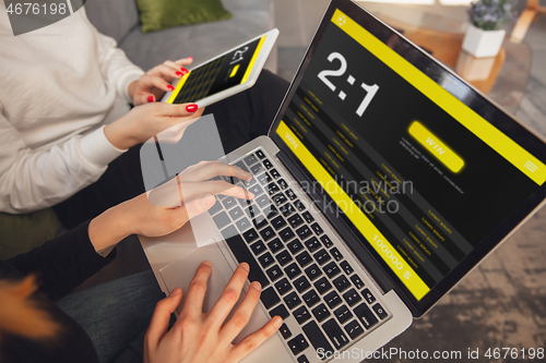 Image of Close up laptop and smartphone screen with mobile app for betting and score