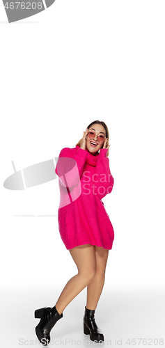 Image of Beautiful young woman in bright pink comfortable sweater, long sleeve isolated on white studio background