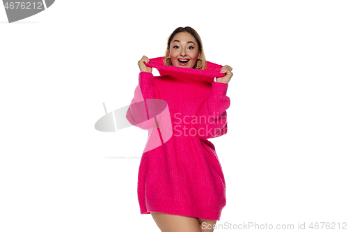 Image of Beautiful young woman in bright pink comfortable sweater, long sleeve isolated on white studio background