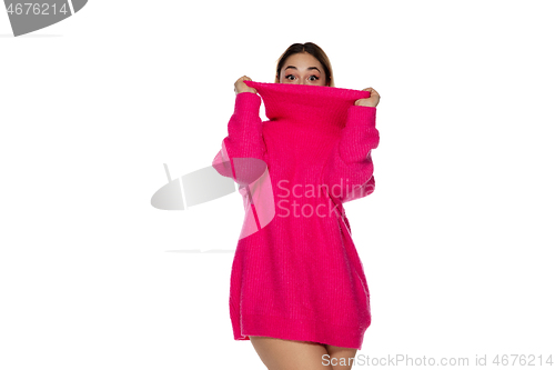 Image of Beautiful young woman in bright pink comfortable sweater, long sleeve isolated on white studio background