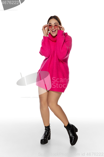 Image of Beautiful young woman in bright pink comfortable sweater, long sleeve isolated on white studio background