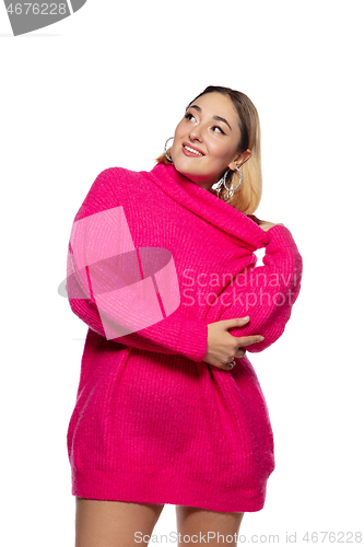 Image of Beautiful young woman in bright pink comfortable sweater, long sleeve isolated on white studio background