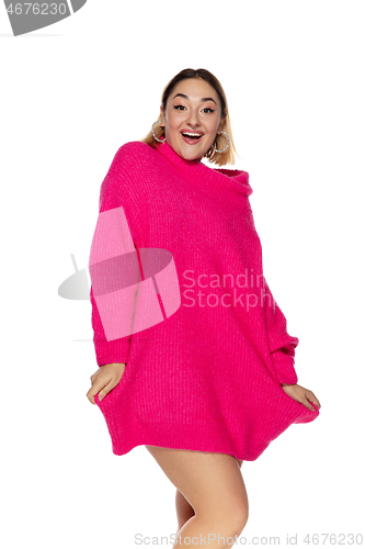 Image of Beautiful young woman in bright pink comfortable sweater, long sleeve isolated on white studio background