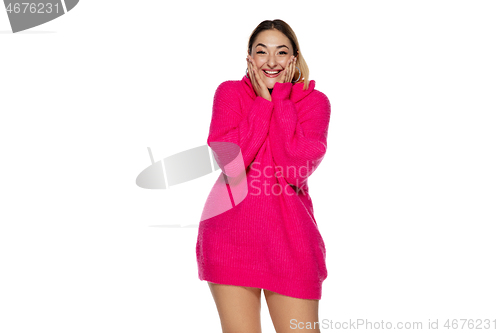 Image of Beautiful young woman in bright pink comfortable sweater, long sleeve isolated on white studio background