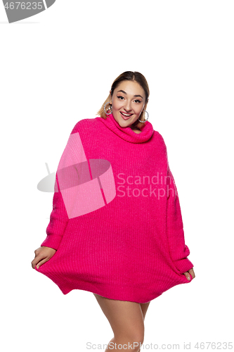 Image of Beautiful young woman in bright pink comfortable sweater, long sleeve isolated on white studio background