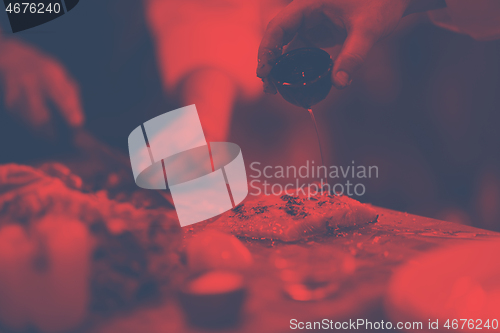 Image of Chef hands preparing marinated Salmon fish