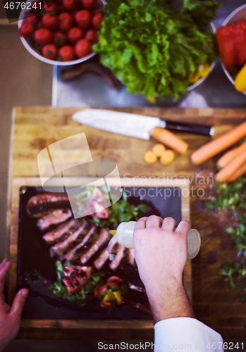 Image of top view of Chef finishing steak meat plate