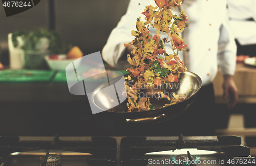 Image of chef flipping vegetables in wok