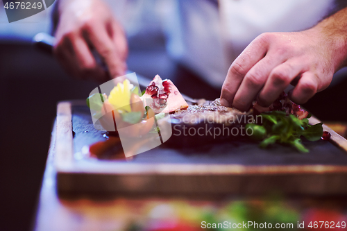 Image of closeup of Chef hands serving beef steak