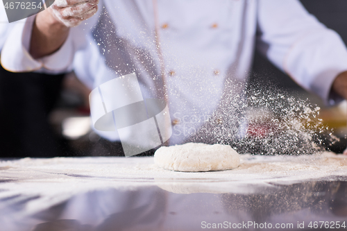 Image of chef hands preparing dough for pizza