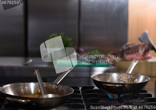 Image of chef preparing food, frying in wok pan