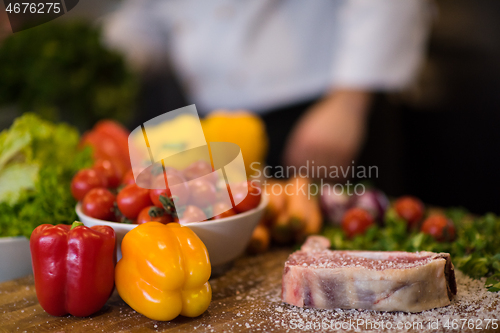 Image of Juicy slice of raw steak on wooden table