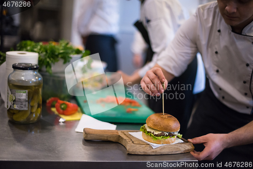 Image of chef finishing burger