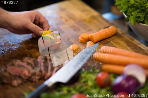 Image of closeup of Chef hands preparing beef steak