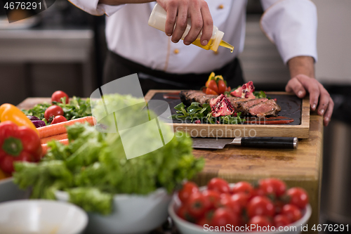 Image of Chef finishing steak meat plate